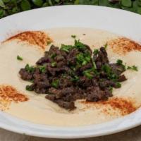 Hummus With Steak Shawarma · Hummus topped with thinly sliced marinated steak.
