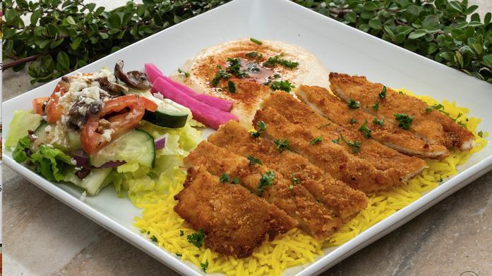 Chicken Schnitzel Plate · Breaded and fried chicken breast seasoned with salt and black pepper served on a bed of basmati rice. Includes hummus and choice of salad.