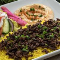 Steak Shawarma Plate · Thinly sliced marinated and sautéed steak served on a bed of basmati rice. Includes hummus a...