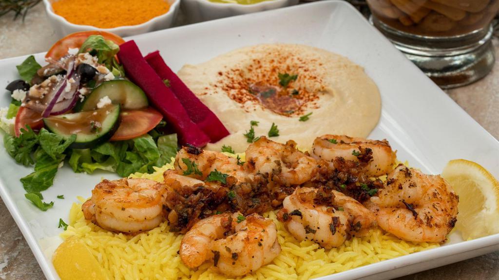 Shrimp Scampi · Sautéed shrimp cooked with onion, garlic, and tomato served on a bed of basmati rice. Includes hummus and choice of salad.