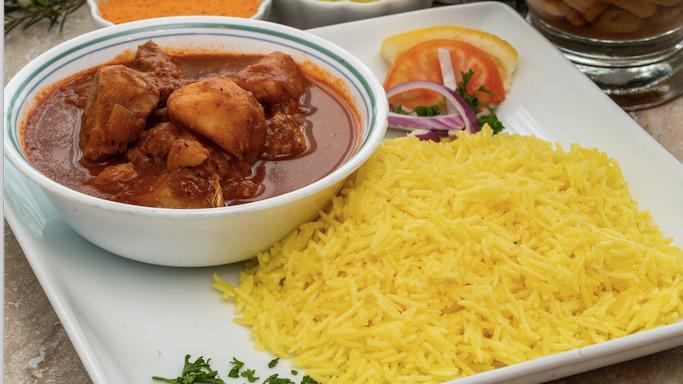 Chicken Curry · Chicken Curry in a tomato based stew with potatoes served on a bed of basmati rice. Includes hummus and choice of salad.