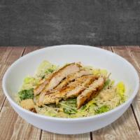 Chicken Caesar Salad · Romaine lettuce tossed in Caesar dressing with grilled chicken and parmesan cheese. / Lechug...