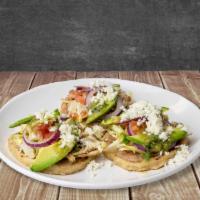 Sopes De Pollo Marinado · Thick tortilla with refried beans and house-made marinated chicken, lettuce queso fresco, an...