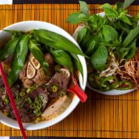 Bún Bò Huế · Spicy lemongrass noodle soup w/ beef shank,
pork paste, pork blood (optional), &
pork hock (...