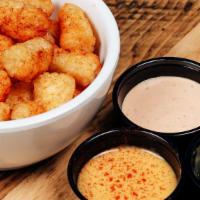 Saucy Tots · Seasoned tots served with sides of beer cheese, poppin cream cheese, and house sauce.