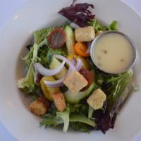 Side Garden Salad · Spring mix cucumbers tomato red onion croutons and champagne vinaigrette