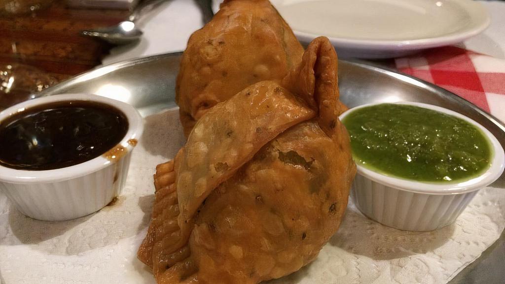 Lamb Samosa · Minced lamb, spinach, green peas and spices wrapped in homemade pastry dough and deep fried.