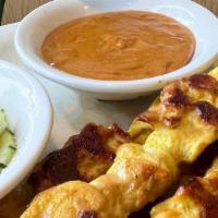 Chicken Satay (4) · Skewered chicken strips marinated served with side of peanut sauce and cucumber salad.
