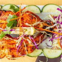 Tandoori Chicken · Gluten free. Roasted chicken leg and thigh marinated in yogurt and homemade spices in a tand...