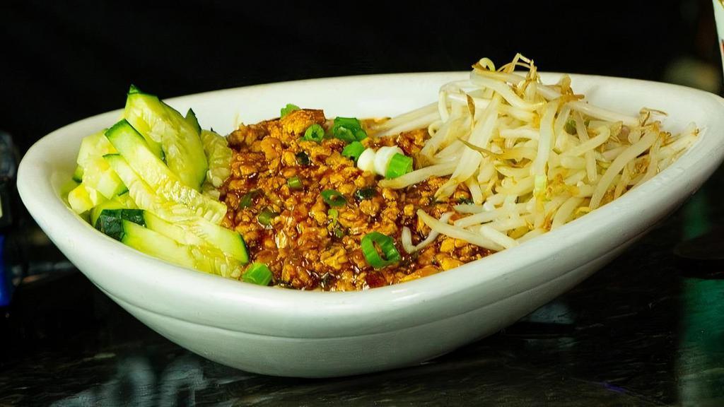 Dan Dan Noodles · Ground white meat chicken, garlic, and scallions. Wok-seared in a chili soy sauce and served over steamed noodles. Finished with steamed bean sprouts and fresh julienne cucumbers.