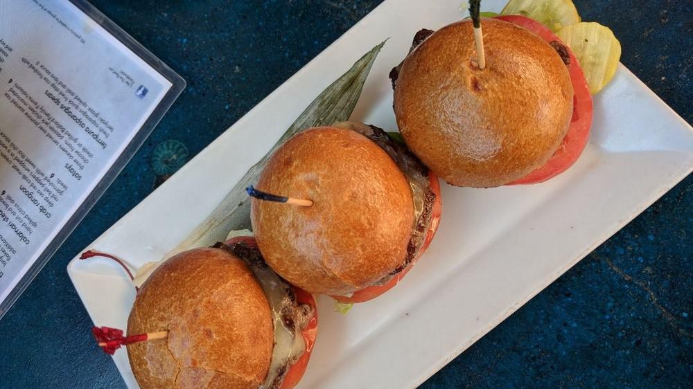Kobe Beef Sliders · Snake River Farms Kobe ground beef patties on toasted brioche buns with melted cheddar cheese, horseradish sauce, lettuce, and tomato.