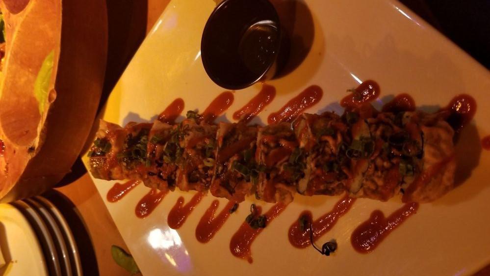 Reef Roll · Cream cheese, smoked salmon and avocado, tempura fried, then laced with eel sauce, sriracha and green onion.