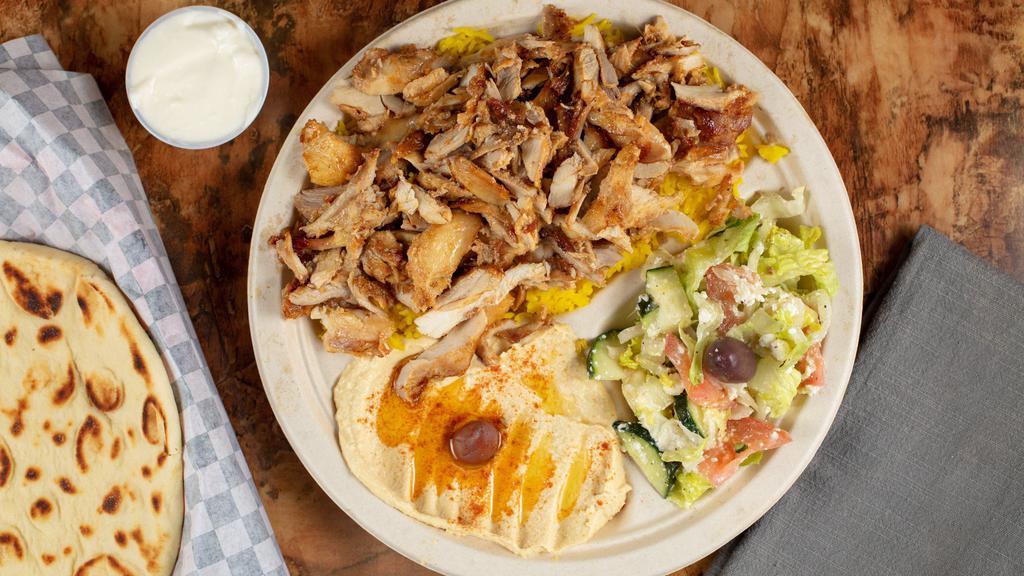 Chicken Shawarma Plate · Marinated grilled chicken breasts served over rice with salad and garlic dip.