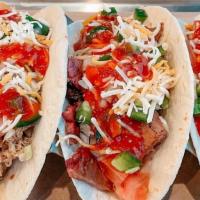 Bbq Taco Trio · 1 pulled pork, 1 pulled chicken and 1 smoked brisket taco each topped with cheddar cheese, d...