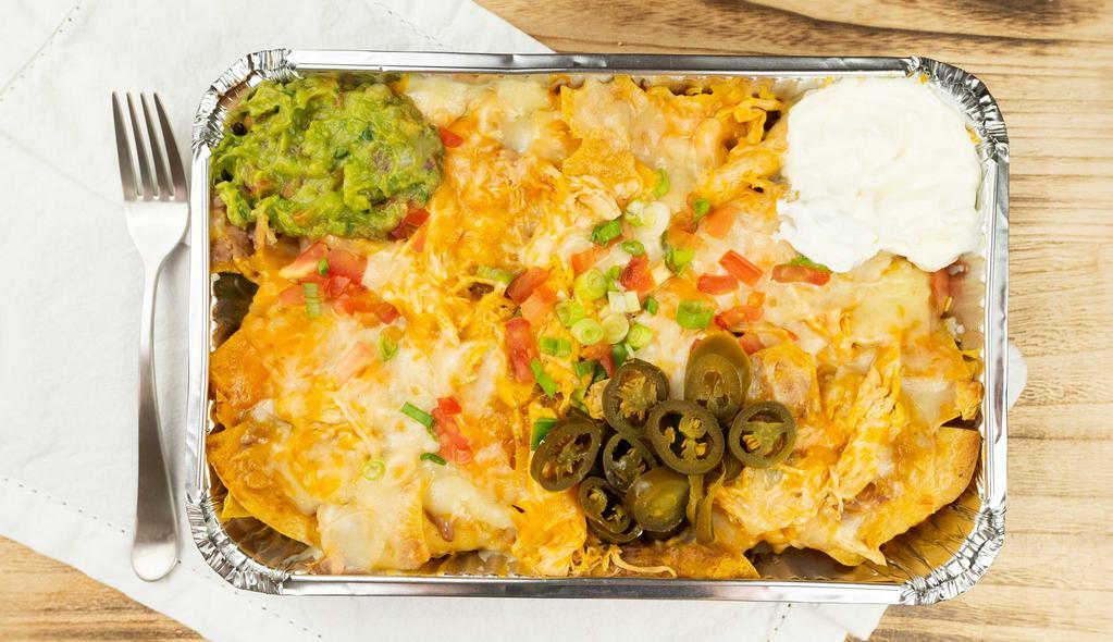 Nachos Tenampa · Fresh corn chips topped with beans, guacamole, sour cream, tomato, green onions, jalapeño peppers, and melted cheese.