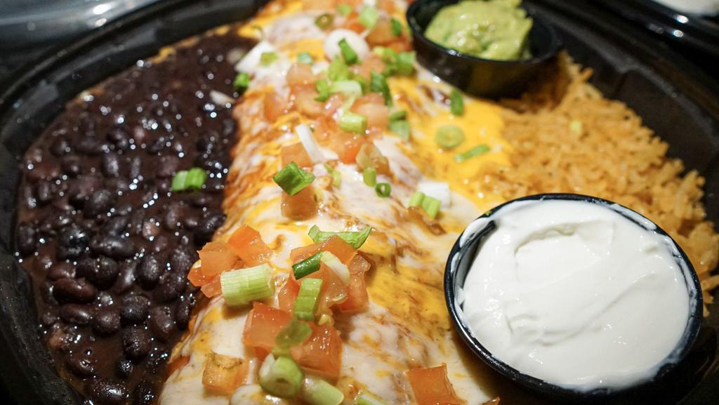 Burrito Tenampa · Filled with top sirloin and cooked with green peppers, mushrooms and onions. Topped with tomato, green onions, guacamole, and sour cream with rice and beans.