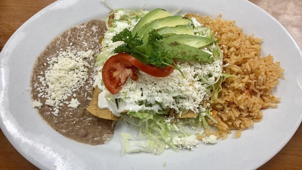 Tacos Dorados · 4 rolled crispy tacos stuffed with tender shredded chicken or beef topped with lettuce, sour cream, and fresh cheese served with rice and beans.