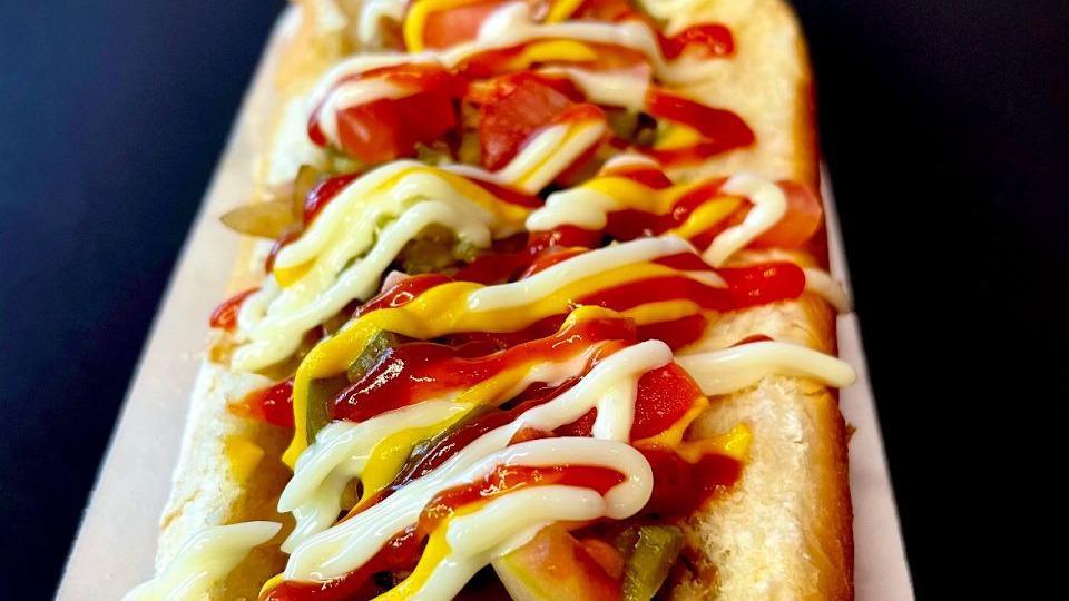 Sonora Dog · Beef dog wrapped in bacon topped with grilled onions, tomatoes, beans, mayo, ketchup and jalapeño salsa.