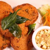 Tod Mun · Fish cake. Fish herb, and green beans, and deep fried. Served with cucumber sweet chili sauc...