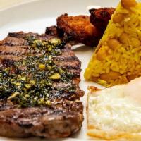 Churrasco A Lo Pobre · Grilled ribeye, chimichurre, beans and rice tacu-tacu, quail eggs, fried bananas