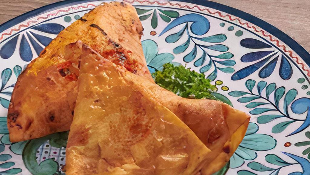 Vegetable Samosa · Two deep fried pastry stuffed with vegetables.