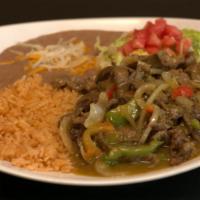 Steak En Salsa Verde · Tender slices of steak cooked with onions, green bell peppers, tomatoes, and all in our home...