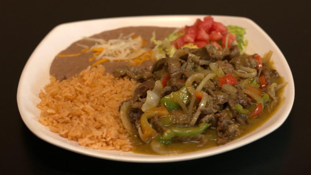 Steak En Salsa Verde · Tender slices of steak cooked with onions, green bell peppers, tomatoes, and all in our homemade tomatillo sauce. Served along with rice, beans, and tortillas.