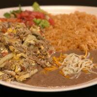 Machaca · Roasted pork cooked with eggs, onions, tomatoes, and bell peppers. Served along with rice, b...