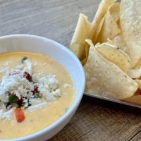 Chips Con Queso  · Topped with pico and cotija cheese. Add Chorizo for an additional charge.