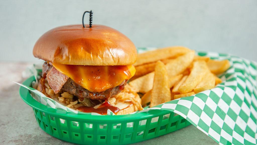 Cowpoke Burger · 1/2 Pound Beef patty with crispy fried onions, smoked bacon, sweet bbq sauce, cheddar cheese, lettuce, tomato, and pickles on a toasted brioche bun.