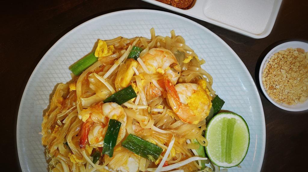 Pad Thai · The most famous Thai noodle dish. Rice noodles stir-fried with chicken, shrimp, eggs, bean sprouts, scallions, topped with chopped peanuts.