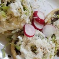 Sopes (3) · Lettuce, choice of meat, monterey jack cheese, beans, sour cream, and tomato sauce.