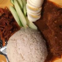 Nasi Lemak · Coconut rice flavored served with chili anchovy, curry chicken, and boiled egg.