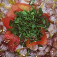 Fava Beans · Fava beans marinated with garlic, lemon juice, and olive oil topped with tomatoes.