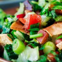 Fettoush Salad · Contains gluten. Fresh romaine lettuce tossed with diced tomatoes, cucumbers, olives, choppe...