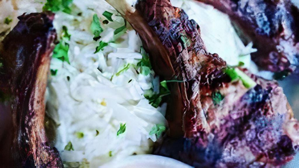 Lamb Chops · Rack of lamb chops marinated and grilled to perfection. Includes a house salad and Italian dressing, a serving of hummus, and a side of rice.