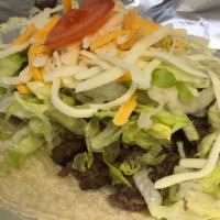 Carne Asada Taco · A burrito that is filled with carne asada, beans, lettuce, cheese, & tomato, on a corn torti...