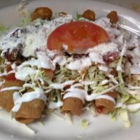 Taquitos · Crispy corn tortilla filled with chicken. Topped with cabbage, cotija cheese, sliced tomatoe...