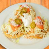 Sopes · Crispy corn sopes, topped with refried beans, your choice of meat, cabbage, sliced tomatoes,...