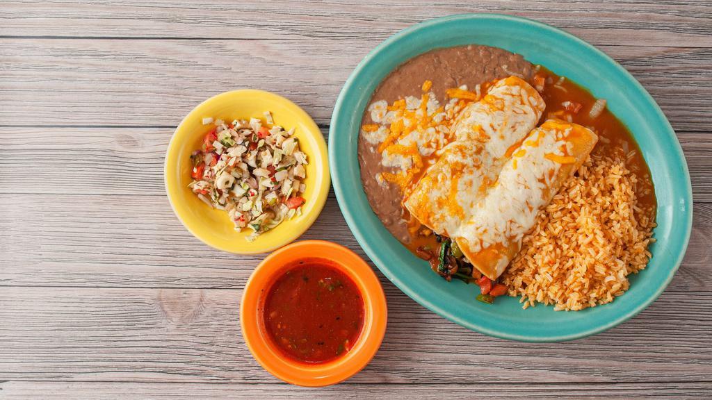 Enchiladas Espinaca · A corn tortilla stuffed with spinach, bell peppers, onions, tomatoes, and mushrooms. Topped with jack cheese and green sauce, served with Mexican rice and beans.