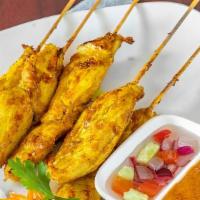 Chicken Satay · Four chicken skewers marinated in yellow curry and served with cucumber sauce and peanut sauce