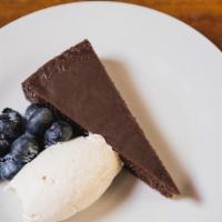 Flourless Chocolate Tort  · Chili and cinnamon spiced, served with whipped cream and berries.