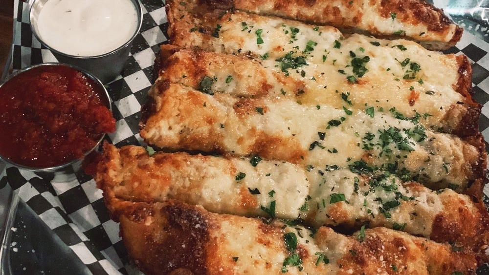 Mother Of All Cheesy Bread · Garlicky butter, brick and smoked white cheddar cheeses, parmesan. Served with crazy sauce and ranch.