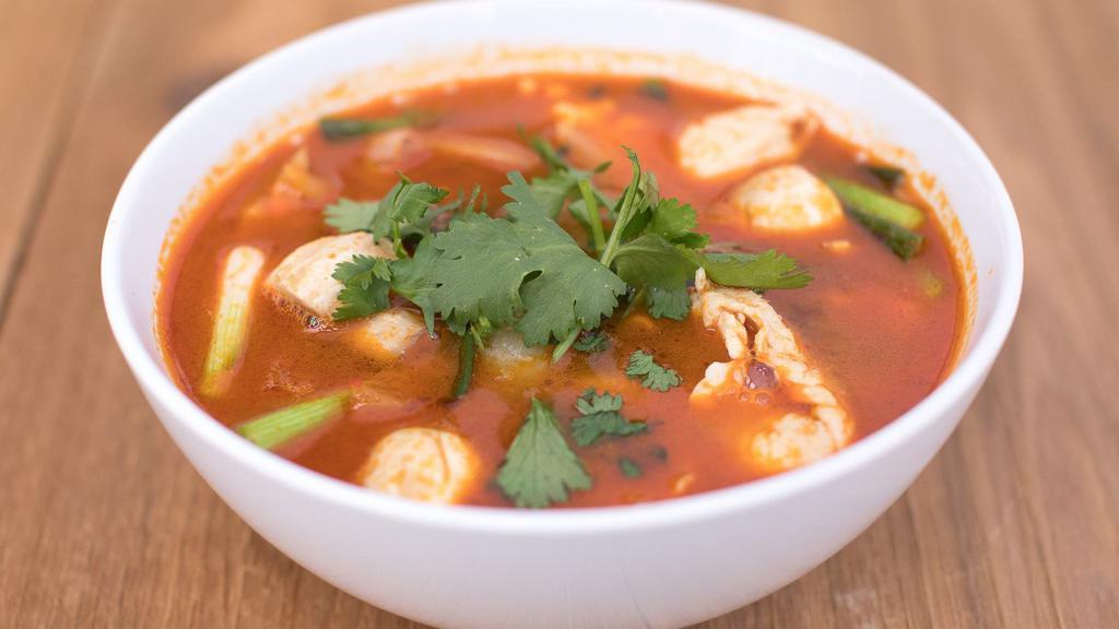 Tom Yum Soup · Clear spicy soup with a touch of lemongrass, galangal root, kaffir leaves, tomatoes, onions, mushrooms, green onions, and topped with cilantro.
