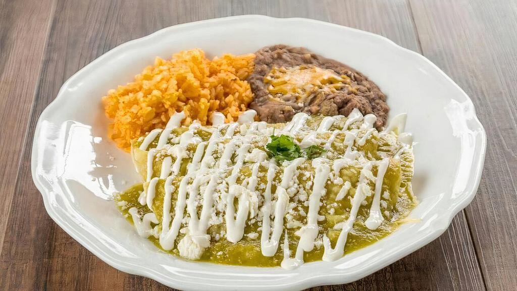Enchiladas Verdes · Tortillas smothered in green sauce filled with choice of meat, topped off with queso fresco, sour cream and onions served with rice and beans.