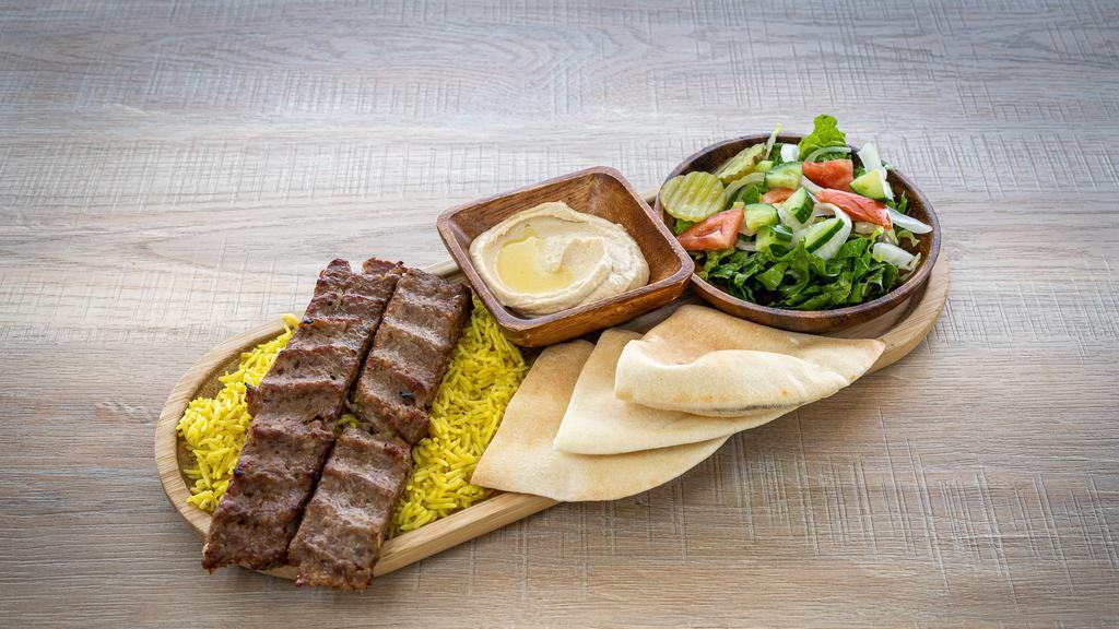 Meat Kabab   · Two skewers of grilled ground meat, served with rice, salad and hummus .