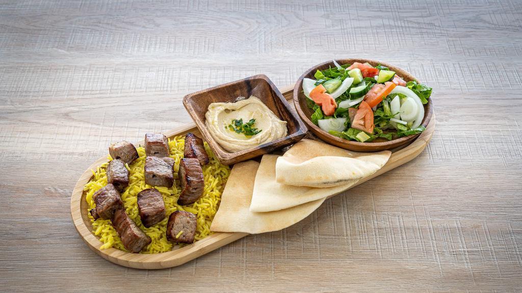 Meat Tikka   · Two skewers of grilled meat marinated in special Food Land seasoning , served with rice, salad, and hummus.
