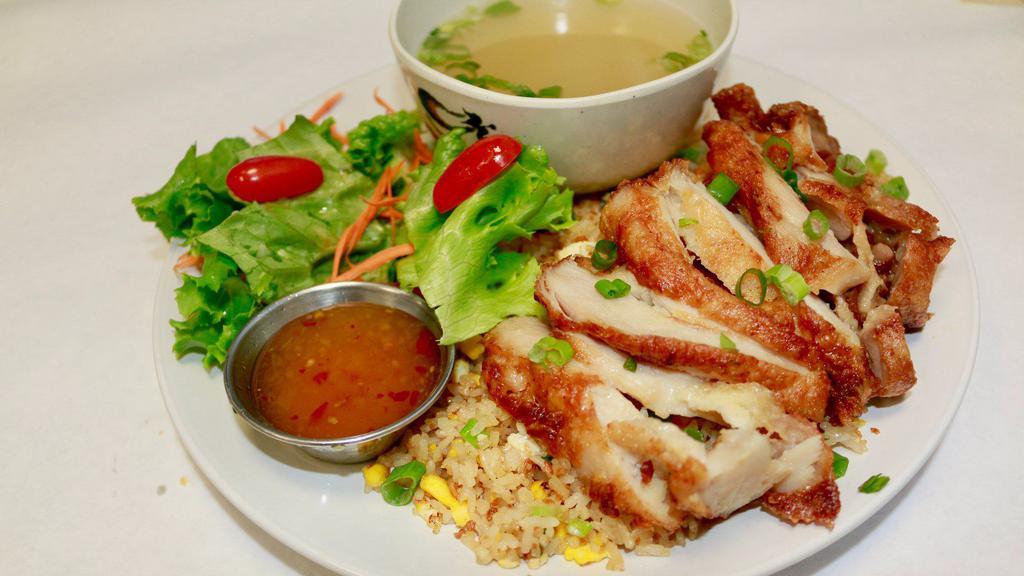 Garlic Fried Rice Topped With Fried Chicken · Original Fried Rice with Egg, Green Onion and Fried Garlic topped with Crispy Chicken. Served with Mix Greens and House Soup with Sweet Pineapple Sauce.