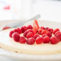Raspberry Cheesecake · Classic cheesecake with a rich, dense, smooth, and creamy consistency topped with fresh rasp...
