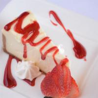 House Cheesecake · Slice of classic cheesecake with raspberry sauce and seasonal fruit.
